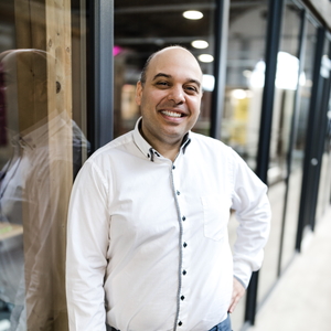 Keywan Ghadami in weißem Hemd im Coworking Space