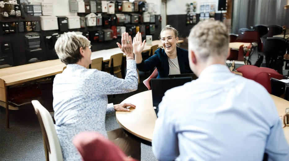 Team freut sich über erfolgreiche Zusammenarbeit in modernem Büro.